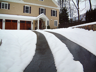 Heated tire tracks in asphalt driveway.