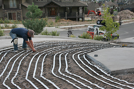 Installing heat cable mats for a heated driveway.