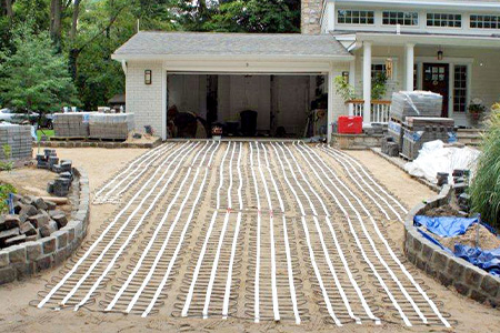 Installation of snow melting mats installed over paver sand.